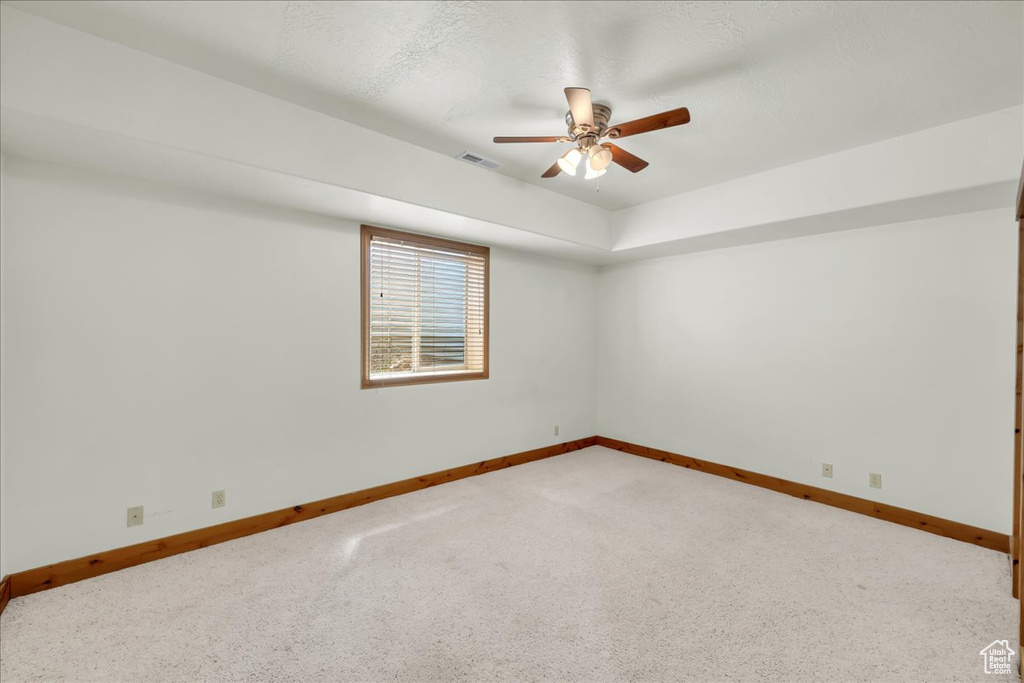 Spare room with a ceiling fan and carpet floors