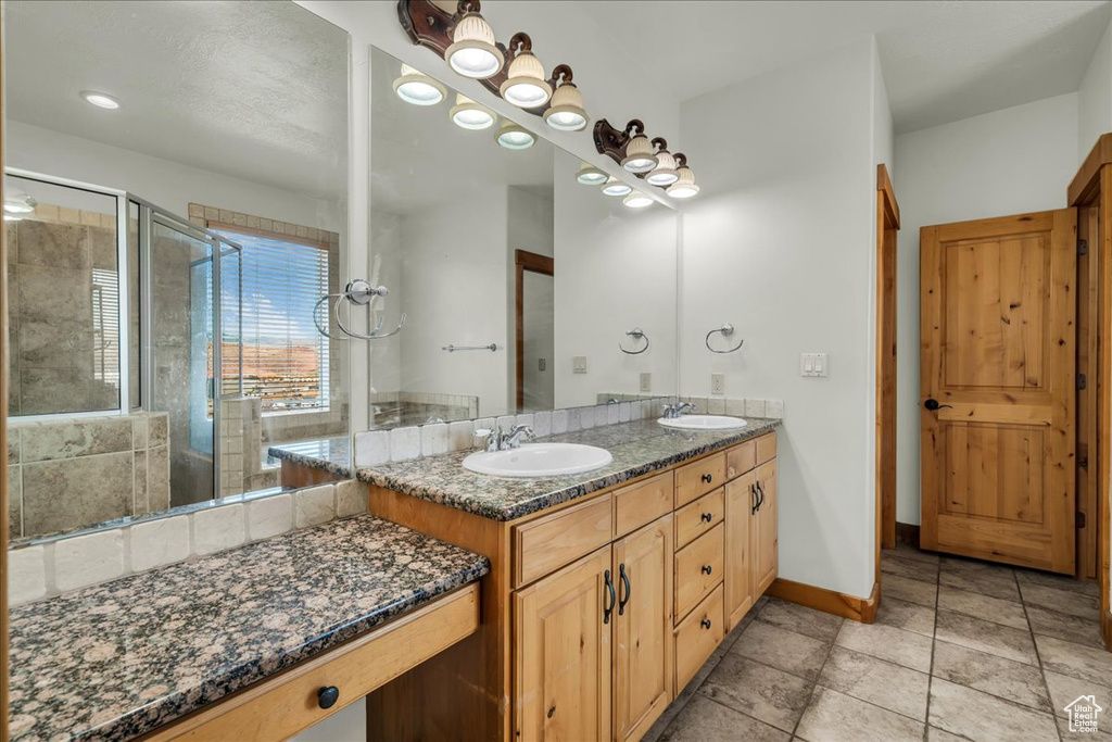 Full bath featuring double vanity and a stall shower