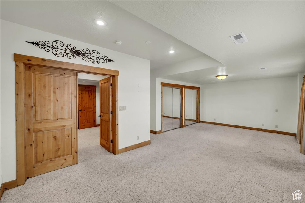 Spare room with light carpet and recessed lighting