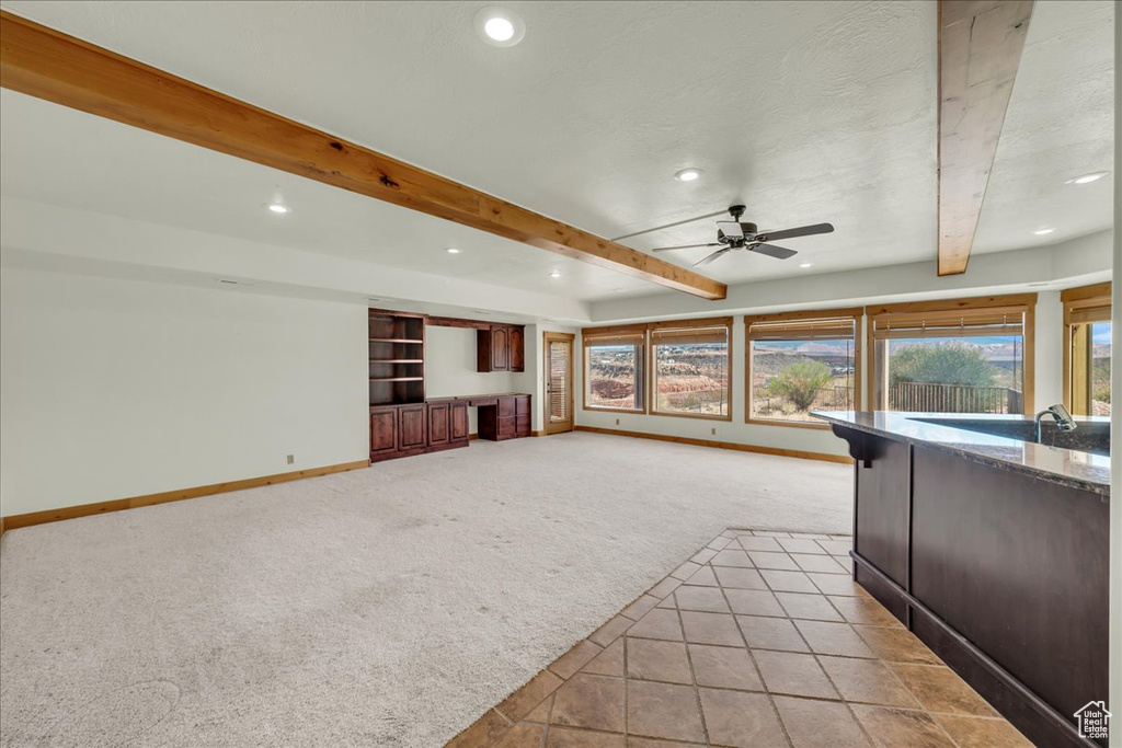 Unfurnished living room featuring light colored carpet, recessed lighting, beamed ceiling, and a ceiling fan