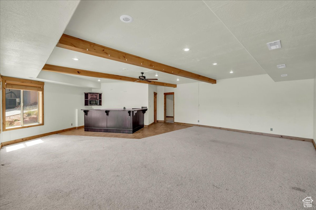 Unfurnished living room featuring recessed lighting, bar, light colored carpet, beamed ceiling, and ceiling fan