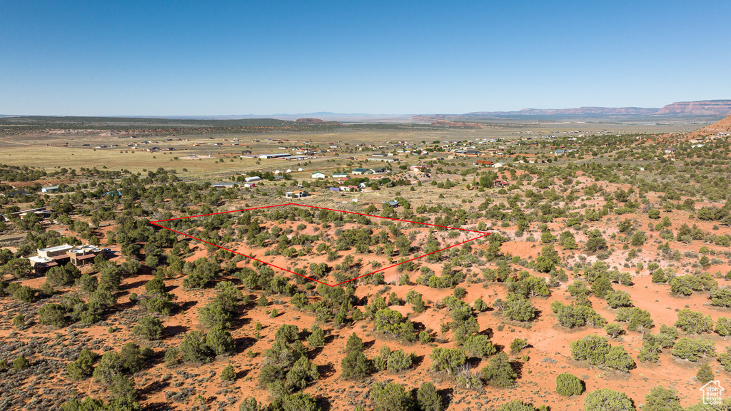 Aerial view of sparsely populated area featuring property parcel outlined and a mountain backdrop