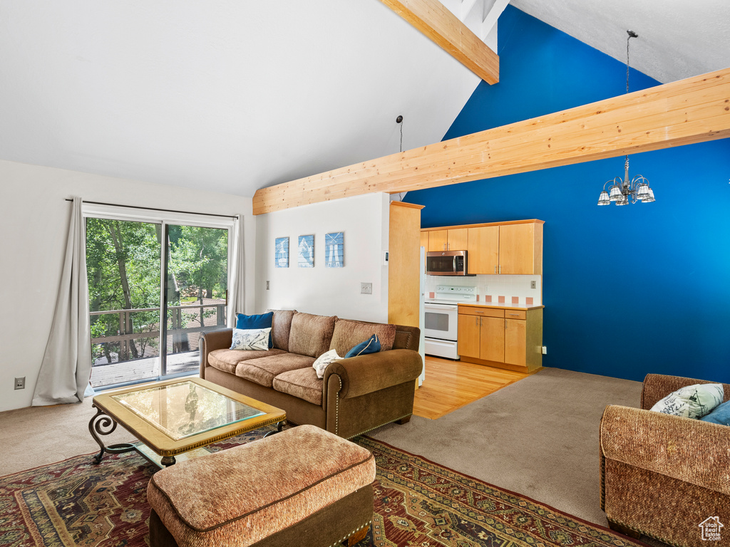 Living area with light colored carpet, a chandelier, beamed ceiling, and high vaulted ceiling