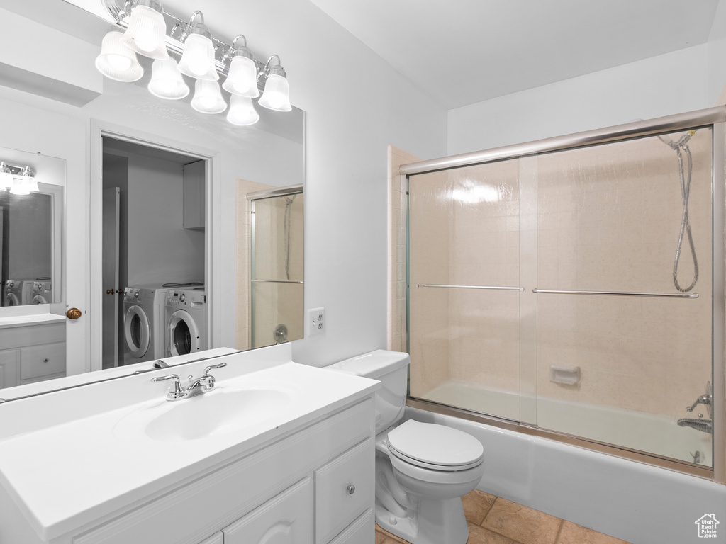 Full bath with separate washer and dryer, vanity, and enclosed tub / shower combo