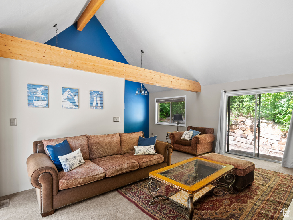 Carpeted living room with beamed ceiling and high vaulted ceiling