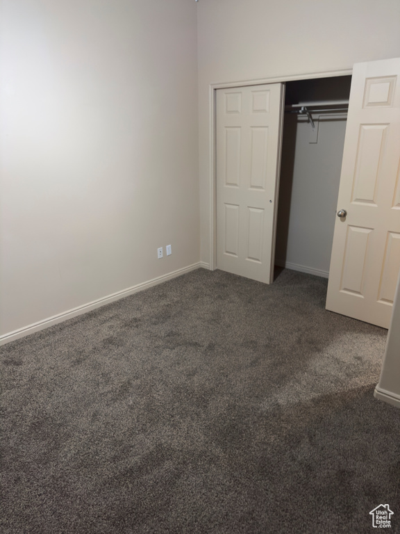 Unfurnished bedroom with carpet and a closet