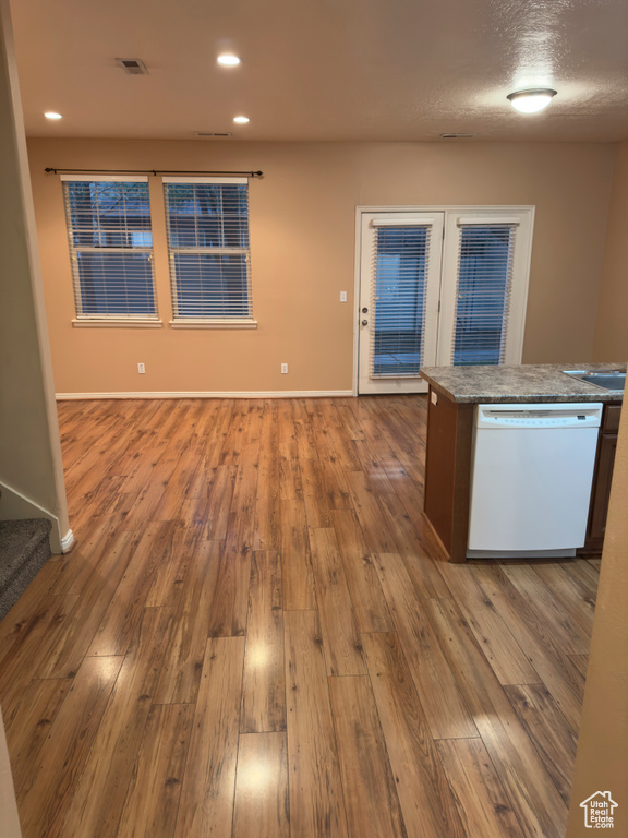 Kitchen with white dishwasher, hardwood / wood-style flooring, recessed lighting, open floor plan, and a center island