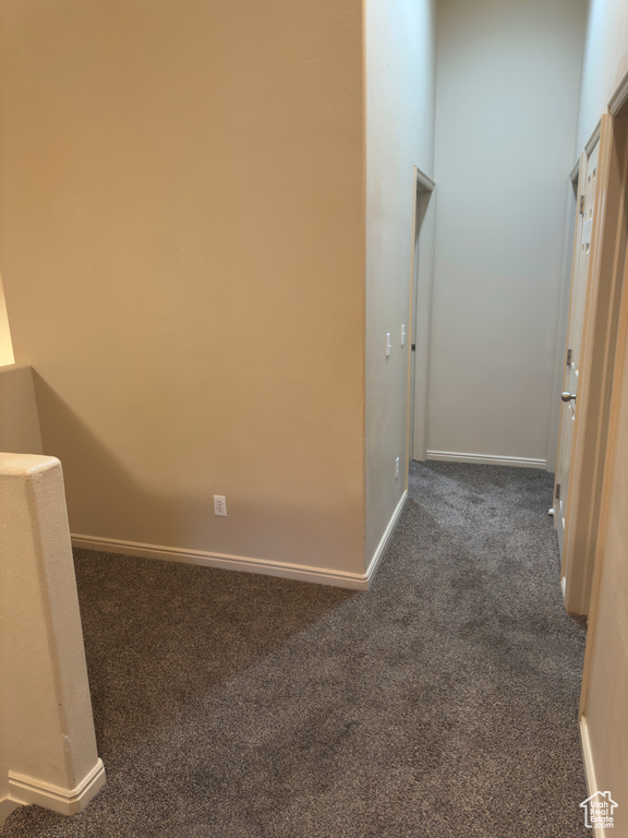 Hallway featuring carpet and baseboards