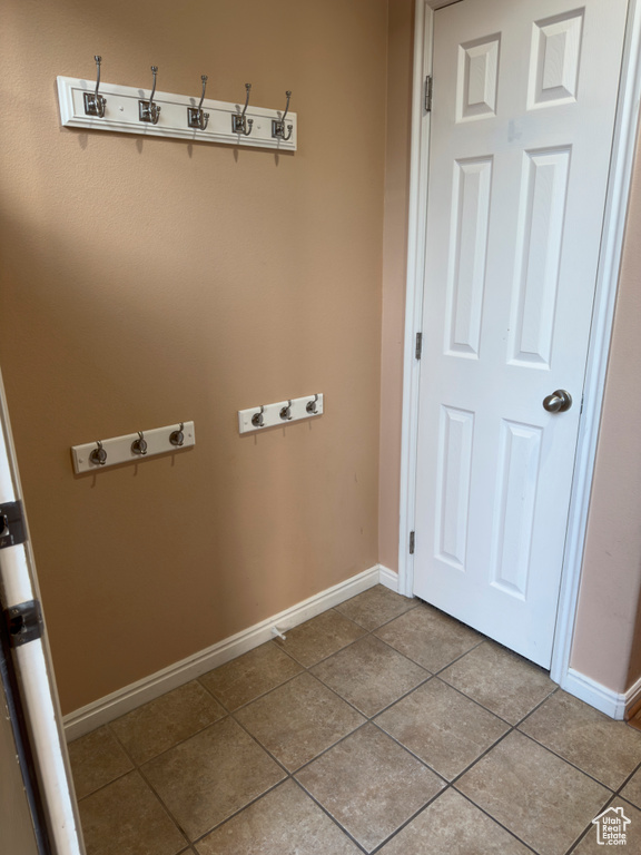 Laundry area with light tile patterned flooring and baseboards