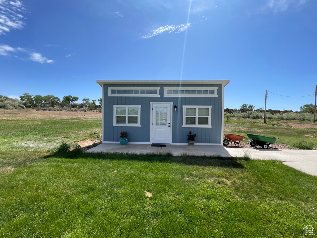 View of front facade with a front yard and an outbuilding