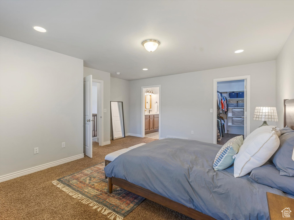 Bedroom featuring light colored carpet, a spacious closet, recessed lighting, ensuite bathroom, and a closet