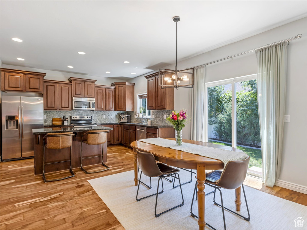 Dining space featuring plenty of natural light, light wood-type flooring, a chandelier, and recessed lighting