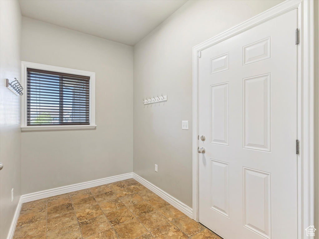 Unfurnished room with baseboards and stone finish floors