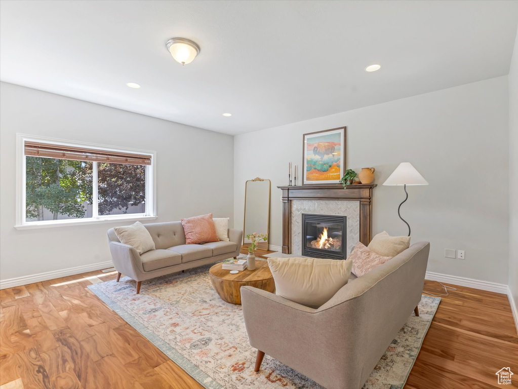 Living room featuring a tiled fireplace, wood finished floors, and recessed lighting