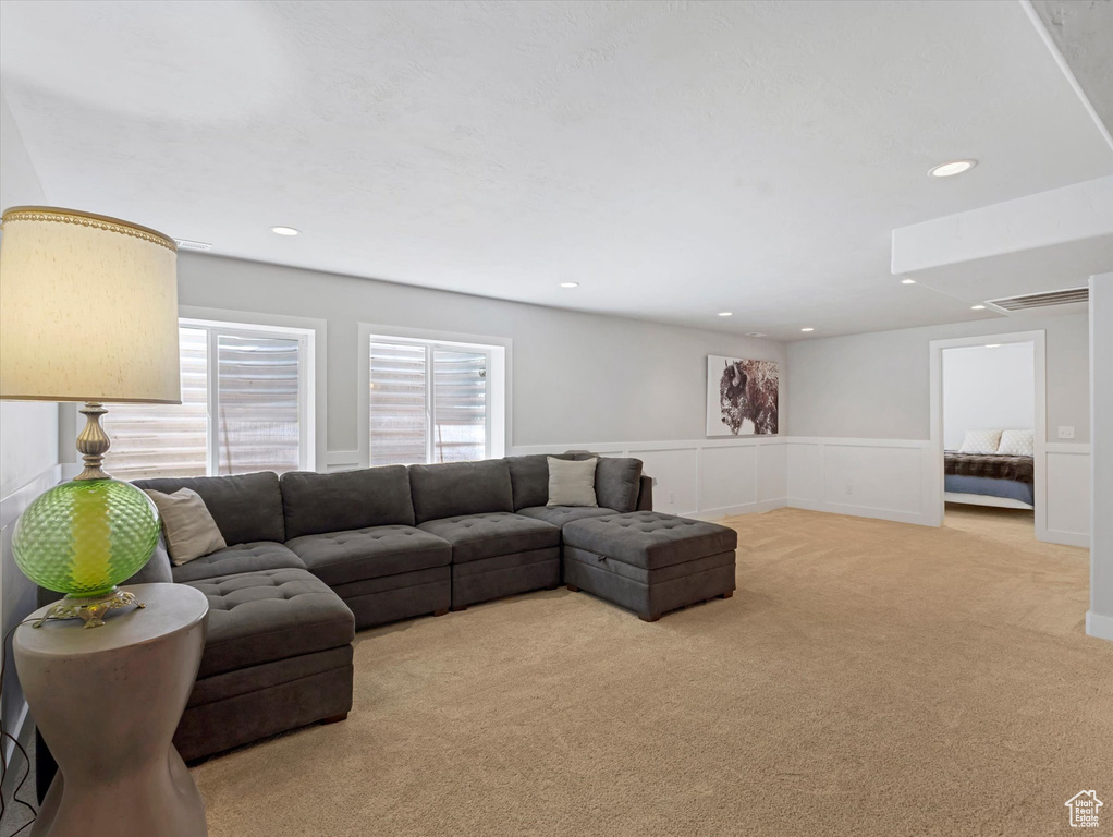 Living room featuring wainscoting, light colored carpet, and recessed lighting