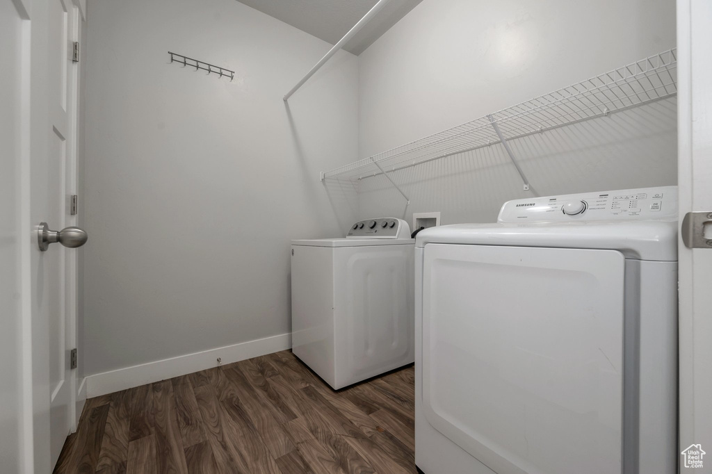 Laundry room with washer and dryer and dark wood finished floors