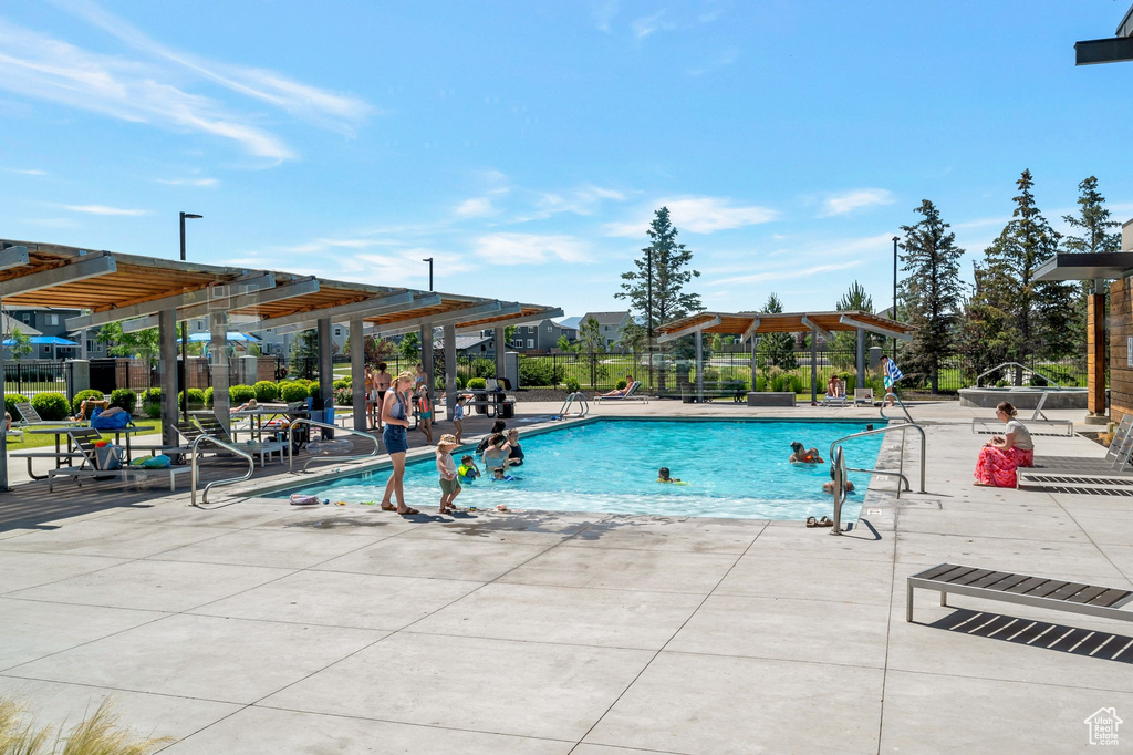 Community pool with a pergola and a patio area