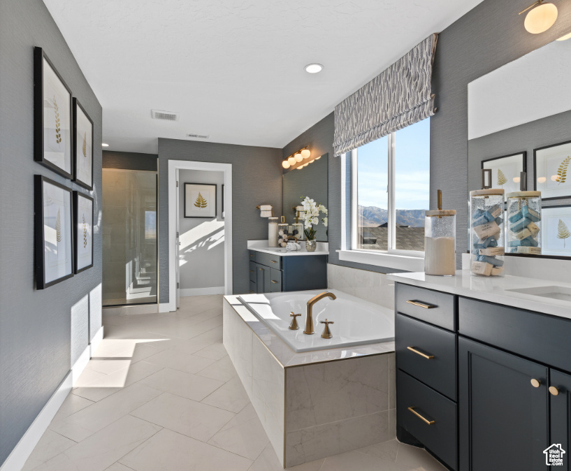 Bathroom with vanity, a bath, a stall shower, and a mountain view
