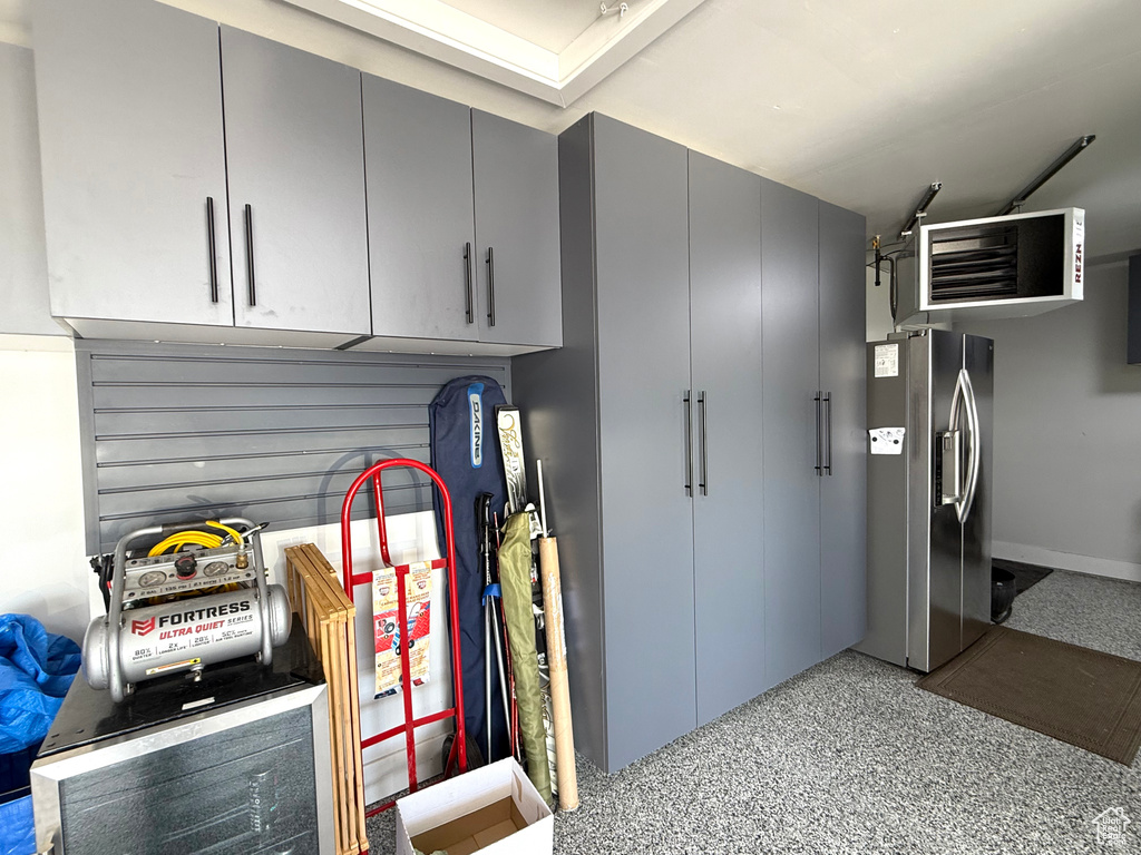 Garage with stainless steel fridge and a heating unit