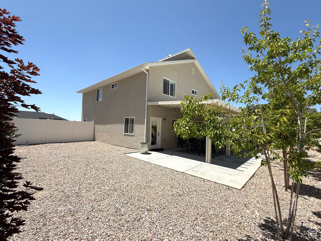 Back of property with stucco siding, a fenced backyard, and a patio area