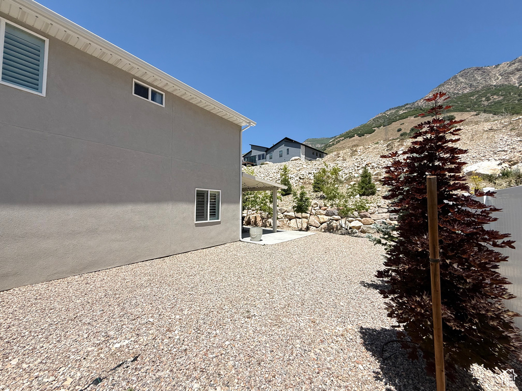 View of home's exterior featuring a patio, a mountain view, and stucco siding