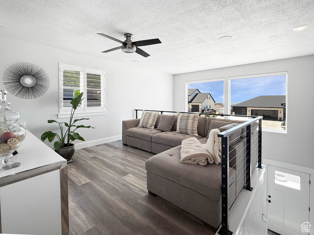 Living room featuring wood finished floors, a textured ceiling, and ceiling fan