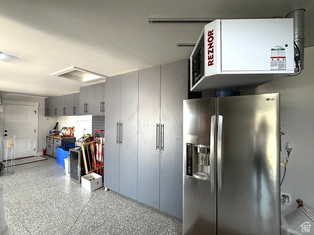 Garage with stainless steel fridge and a heating unit