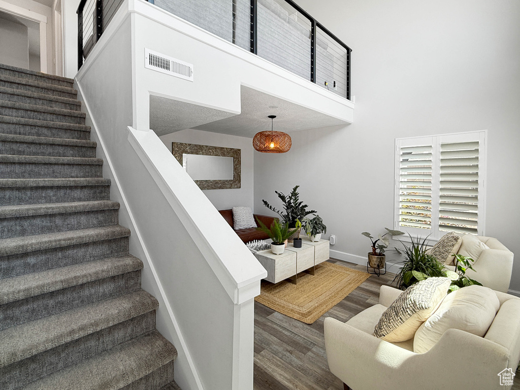 Staircase featuring a high ceiling and wood finished floors