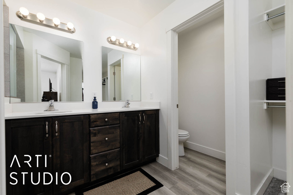 Bathroom featuring double vanity and wood finished floors
