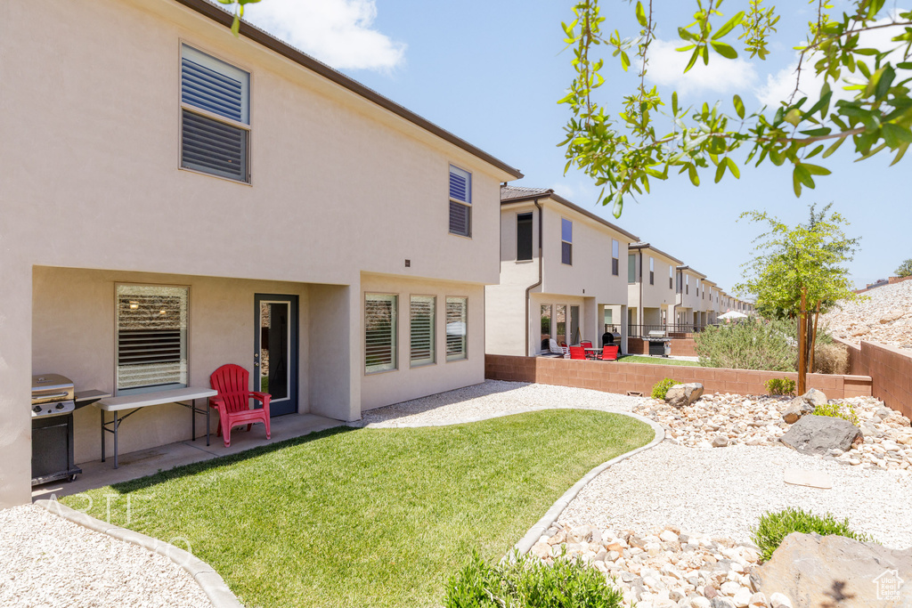 Back of property with stucco siding and a patio