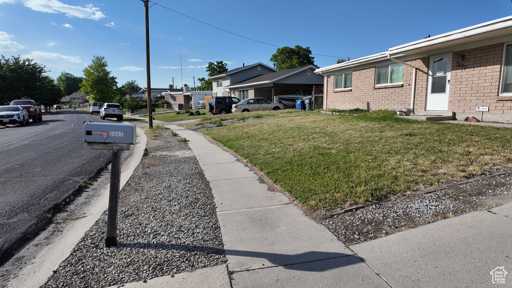 View of green lawn with a residential view