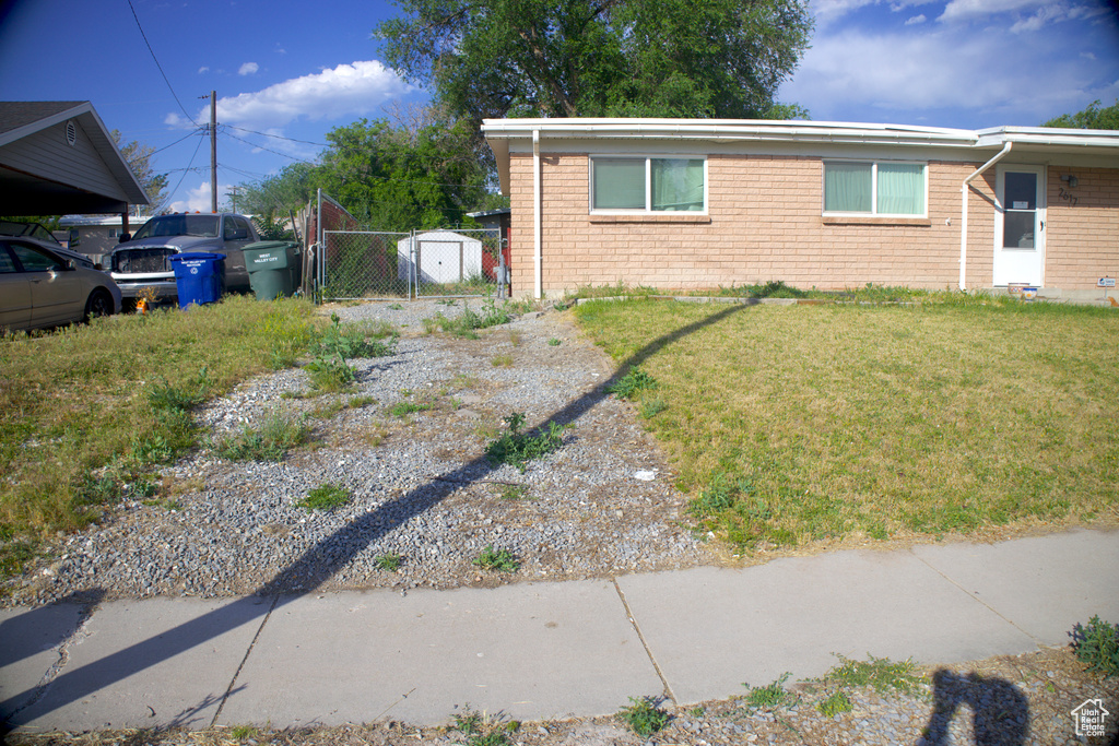 View of side of home with a gate and brick siding