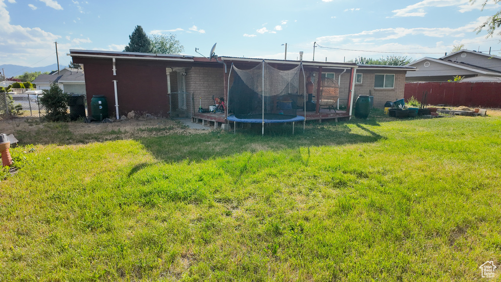 Back of house with a trampoline