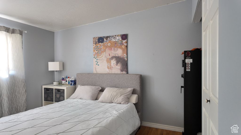 Bedroom with wood finished floors and baseboards