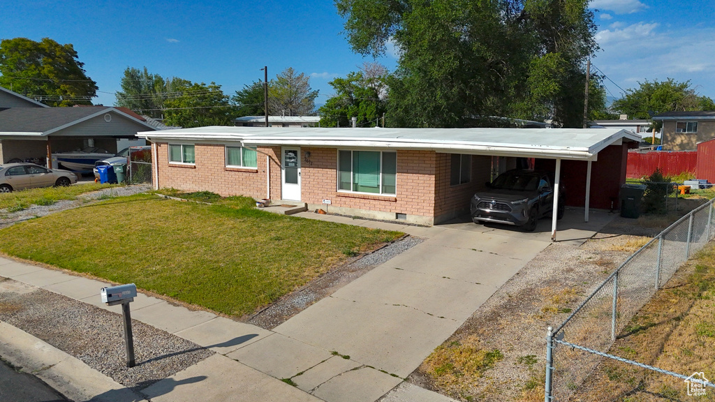Ranch-style home with driveway, a carport, and brick siding
