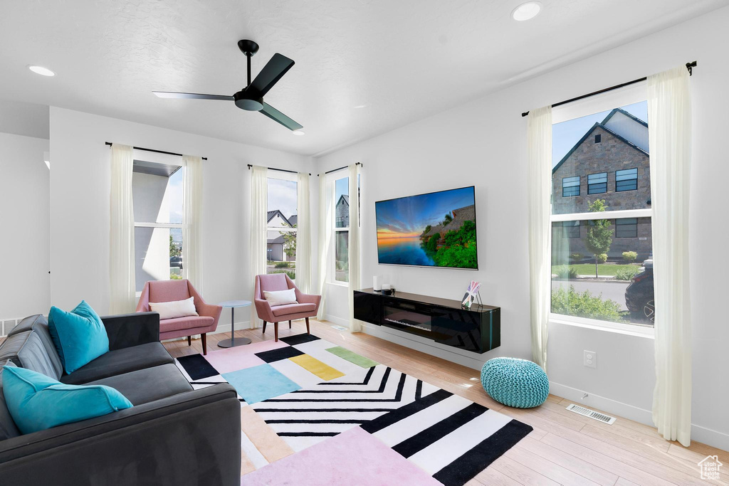 Living room featuring light wood finished floors, ceiling fan, and recessed lighting