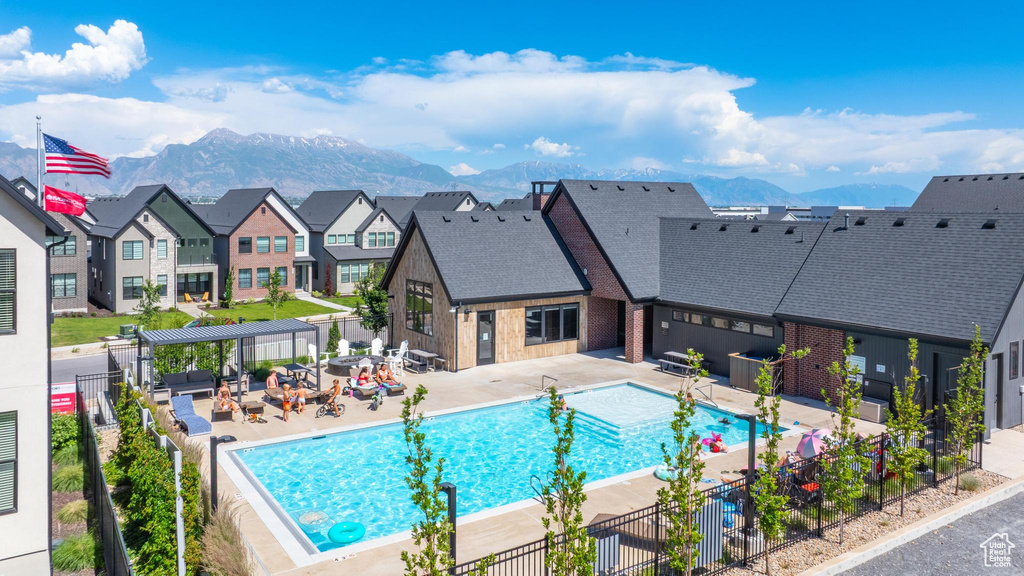 Community pool featuring a pergola, a mountain view, a patio area, and a residential view