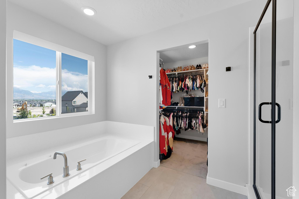 Bathroom featuring a mountain view, a shower stall, a garden tub, a walk in closet, and recessed lighting