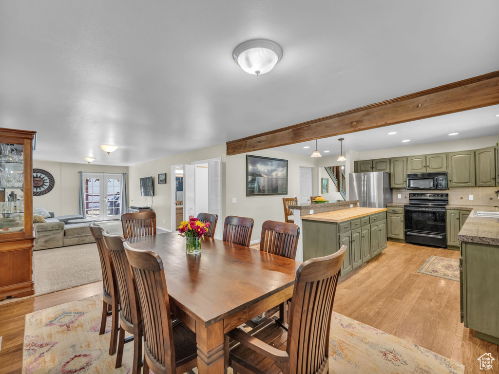 Dining space with light wood-type flooring, beam ceiling, and recessed lighting
