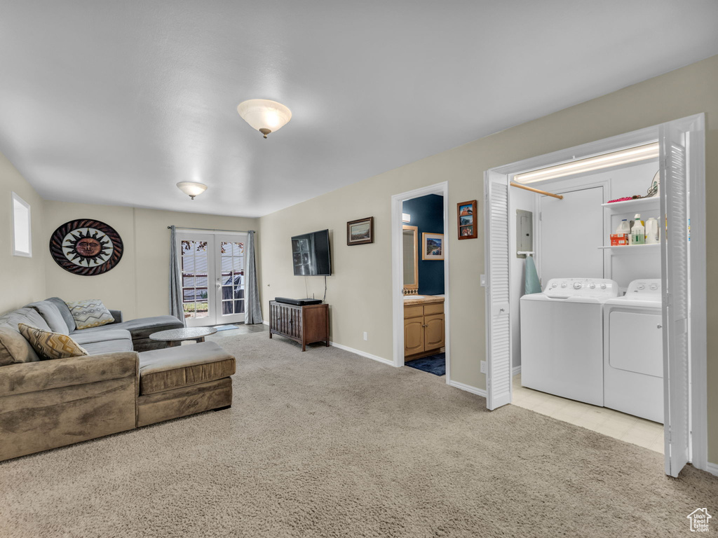Carpeted living room with washer and clothes dryer and baseboards