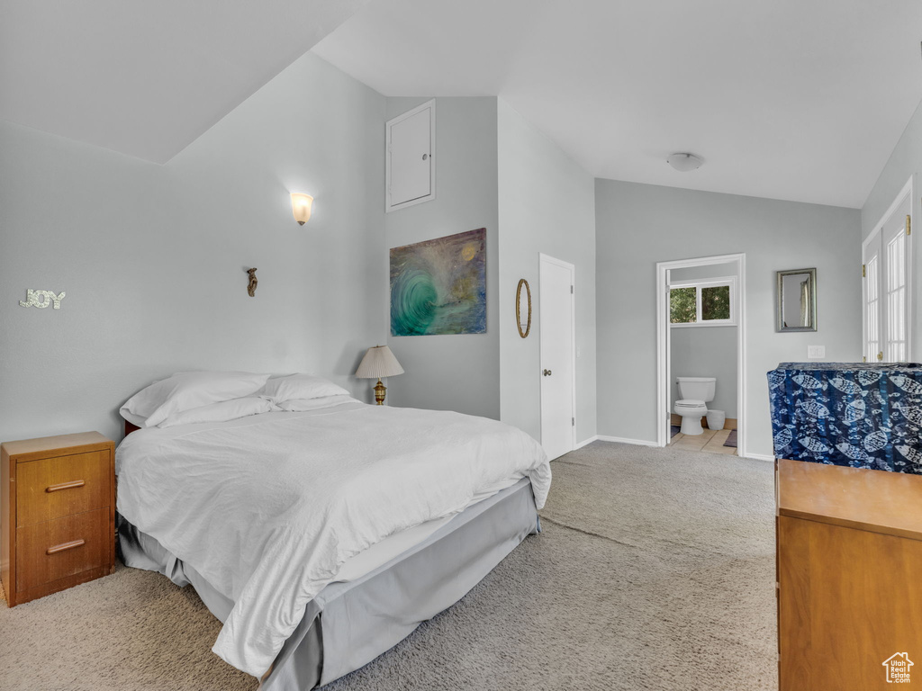 Carpeted bedroom featuring lofted ceiling and ensuite bathroom