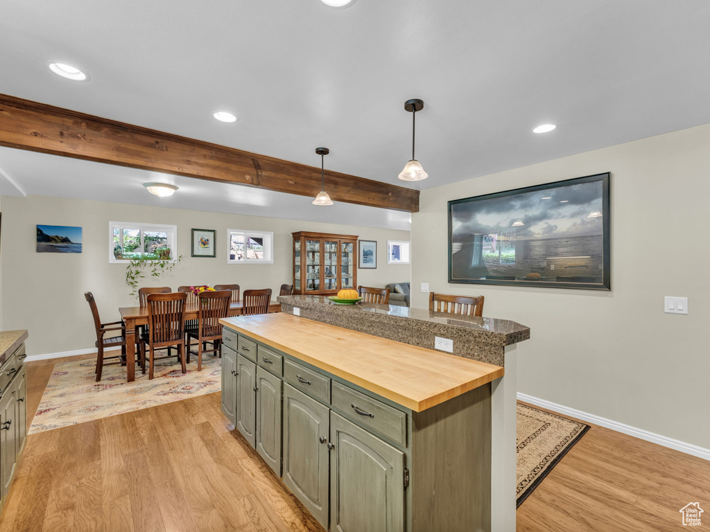 Kitchen featuring wood counters, light wood finished floors, recessed lighting, a center island, and decorative light fixtures