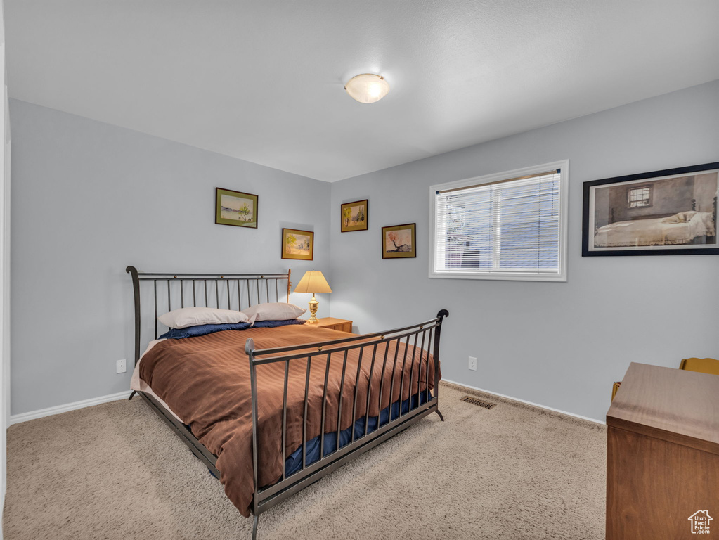Bedroom featuring carpet and baseboards