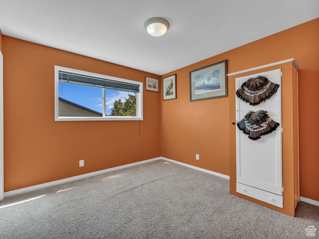 Carpeted empty room with baseboards