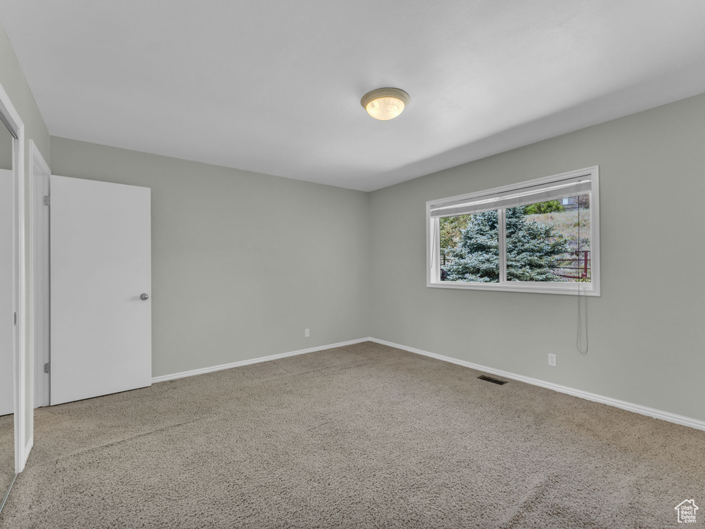 Carpeted empty room with baseboards