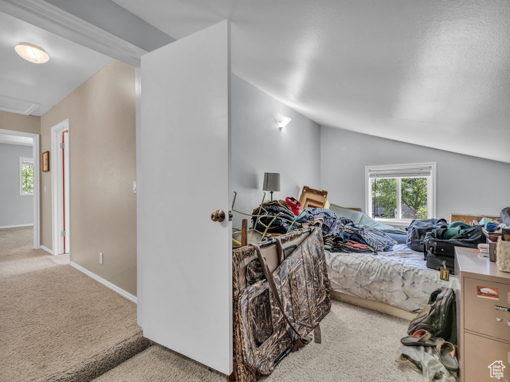 Bedroom featuring carpet, lofted ceiling, and attic access