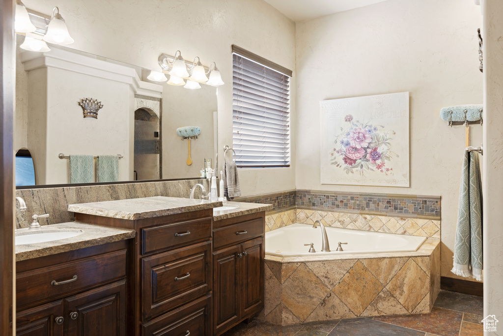Full bathroom with two vanities, a garden tub, and stone tile floors