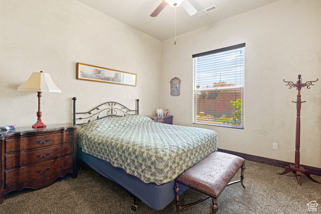 Carpeted bedroom with a ceiling fan