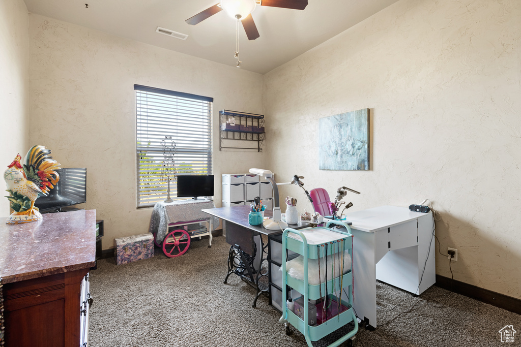 Home office with a ceiling fan, carpet flooring, and a textured wall