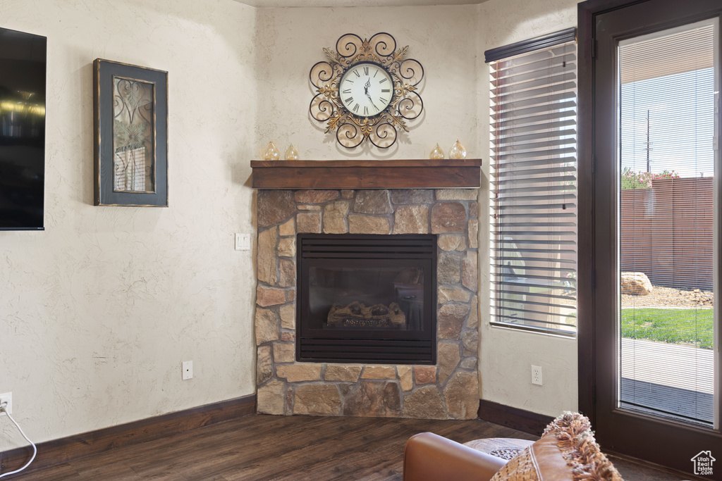 Living area featuring wood finished floors, a fireplace, and a textured wall